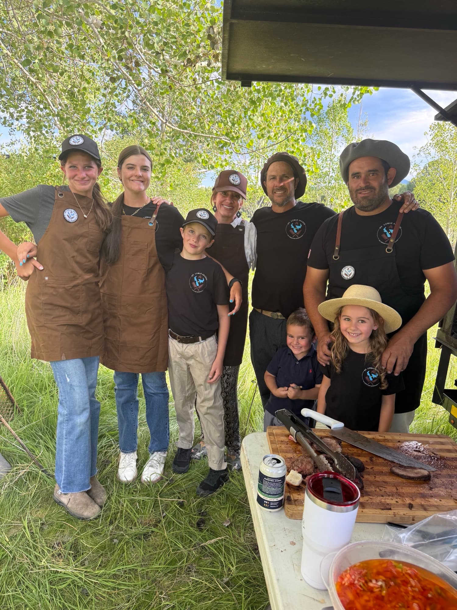 The Villanueva family and Pancho gathered behind the carving board at an asado