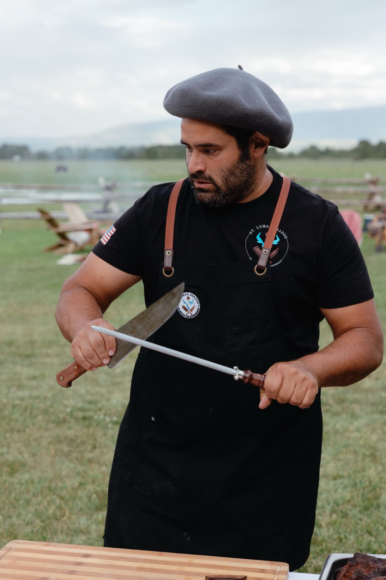 Pancho in his gaucho beret and St Lumaz Asados apron, sharpening his knife before service